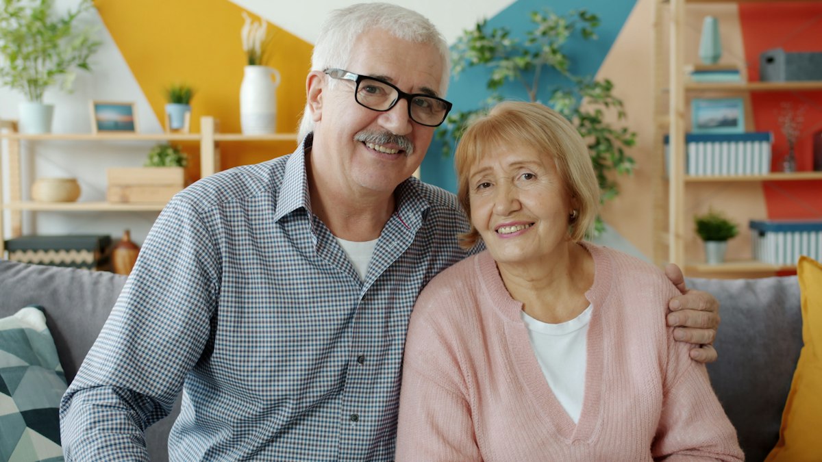 Smiling couple at home after simplifying their monthly payments